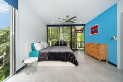 a bedroom with a bed and a ceiling fan at Bangtao Beach Garden - 2 BR Apartment in Surin Beach