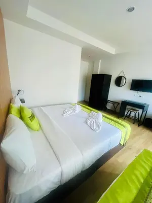 a bedroom with a large white bed with yellow pillows at 28 Boutique Hotel - Newly Renovated in Patong Beach