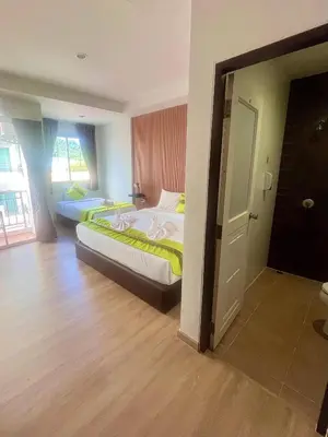a bedroom with two beds and a door to a room at 28 Boutique Hotel - Newly Renovated in Patong Beach