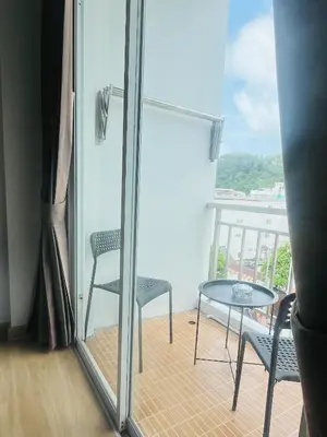 a balcony with two chairs and a glass table at 28 Boutique Hotel - Newly Renovated in Patong Beach
