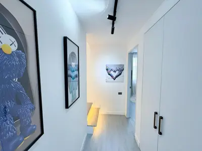 a hallway with a white wall with a picture of an owl at Townhouse Bellano 3BR FamilyLaguna Park Bang Tao in Laguna Phuket