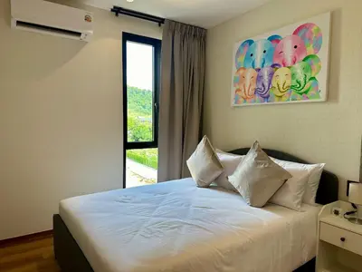a bedroom with a white bed with a window at 1BR Title Halo at Naiyang beach in Nai Yang Beach
