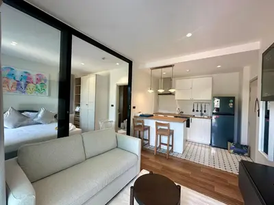 a living room with a white couch and a kitchen at 1BR Title Halo at Naiyang beach in Nai Yang Beach