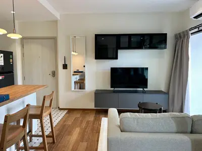 a living room with a couch and a flat screen tv at 1BR Title Halo at Naiyang beach in Nai Yang Beach