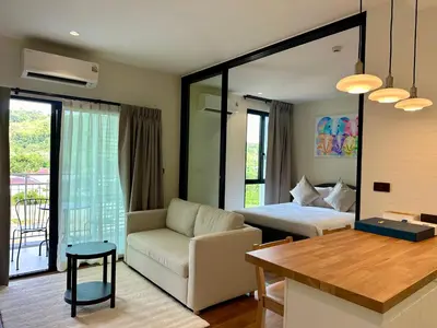 a bedroom with a bed and a couch and a table at 1BR Title Halo at Naiyang beach in Nai Yang Beach
