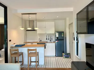 a kitchen with white cabinets and a blue refrigerator at 1BR Title Halo at Naiyang beach in Nai Yang Beach