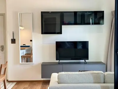 a living room with a couch and a flat screen tv at 1BR Title Halo at Naiyang beach in Nai Yang Beach