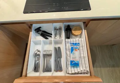 a drawer with silver utensils in a cabinet at Laguna Beachside Residences by Beringela in Bang Tao Beach
