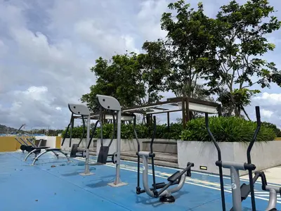 a row of exercise equipment next to a swimming pool at Laguna Beachside Residences by Beringela in Bang Tao Beach