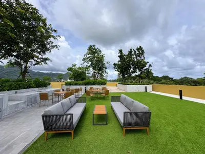 a patio with couches and chairs and tables and grass at Laguna Beachside Residences by Beringela in Bang Tao Beach