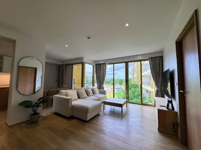 a living room with a white couch and a mirror at Laguna Beachside Residences by Beringela in Bang Tao Beach