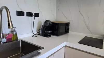 a microwave sitting on a kitchen counter next to a sink at Chalong Marina Bay View by SP in Ban Bang Chak
