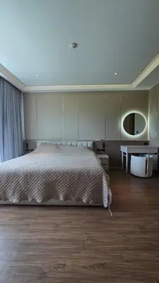 a bedroom with a large bed and a table at Chalong Marina Bay View by SP in Ban Bang Chak