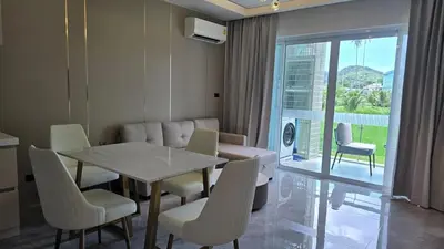 a dining room with a table and chairs and a balcony at Chalong Marina Bay View by SP in Ban Bang Chak