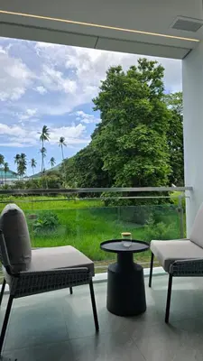 a room with two chairs and a table and a large window at Chalong Marina Bay View by SP in Ban Bang Chak