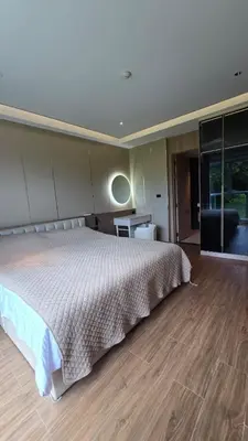a bedroom with a large bed and a wooden floor at Chalong Marina Bay View by SP in Ban Bang Chak