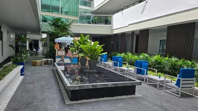 a courtyard in a building with chairs and plants at Chalong Marina Bay View by SP in Ban Bang Chak