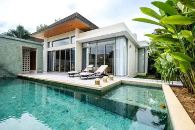 a villa with a swimming pool in front of a house at Khanaen Luxury Pool Villa by SP in Ban Chin Tham Mai