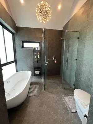 a bathroom with a tub and a glass shower at The Granary Villas by SP in Ban Pak Lak