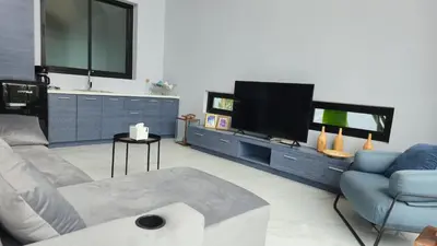 a living room with a couch and a flat screen tv at The Granary Villas by SP in Ban Pak Lak