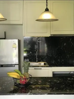 a kitchen with a pineapple and a bowl of fruit on a counter at The Palmirah Surin by SP in Surin Beach