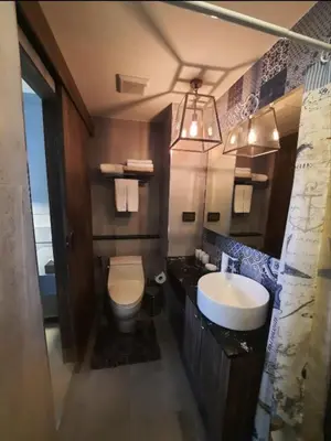a bathroom with a sink and a toilet and a mirror at The Palmirah Surin by SP in Surin Beach