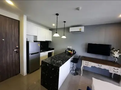a kitchen with a black counter and a refrigerator at The Palmirah Surin by SP in Surin Beach