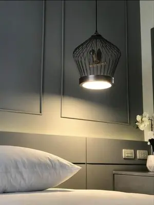 a bedroom with a bed with a light above it at The Palmirah Surin by SP in Surin Beach