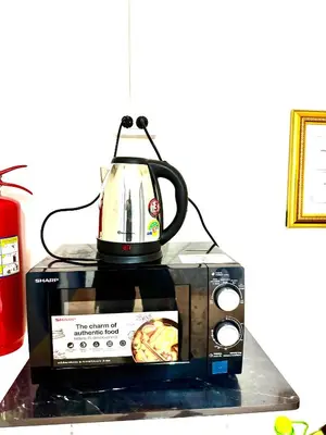 a microwave with a tea kettle on top of it at Sundiva Guest House in Patong Beach