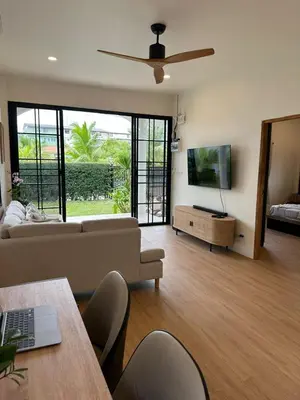a living room with a couch and a flat screen tv at Chalong Home Phuket in Phuket Town
