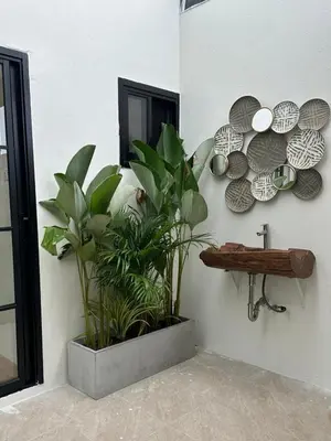 a room with plants and plates on a wall at Chalong Home Phuket in Phuket Town