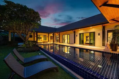 a swimming pool in a house with two chairs next to it at Villa Haeata 3BR Private Pool Nai Harn Beach in Nai Harn Beach