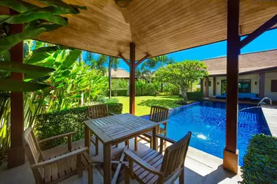 a patio with a table and chairs and a swimming pool at Villa Haeata 3BR Private Pool Nai Harn Beach in Nai Harn Beach