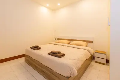 a bedroom with a bed with two towels on it at Homehug in Ban Thalat Choeng Thale