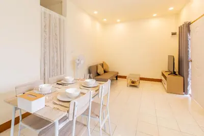 a dining room with a table and chairs and a television at Homehug in Ban Thalat Choeng Thale