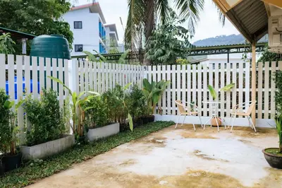 a white fence with two chairs and plants at Homehug in Ban Thalat Choeng Thale