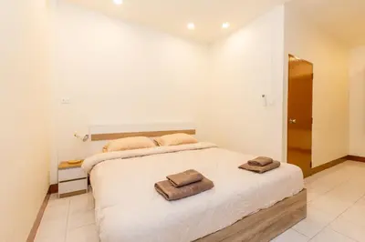 a bedroom with a bed with two towels on it at Homehug in Ban Thalat Choeng Thale