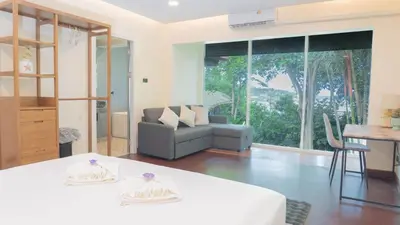 a living room with a couch and a table at Jaokhun Hilltop Patong, Phuket in Patong Beach