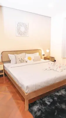 a large bed with white sheets and flowers on it at Jaokhun Hilltop Patong, Phuket in Patong Beach