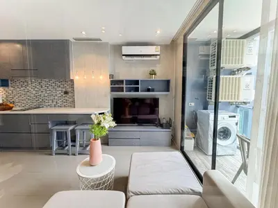 a living room with a couch and a kitchen at Amazing 1Bdr Kamala City Gate 3 Pools, Coworking in Kamala Beach