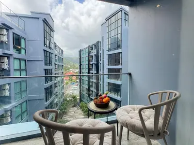 a balcony with two chairs and a bowl of fruit on a table at Amazing 1Bdr Kamala City Gate 3 Pools, Coworking in Kamala Beach