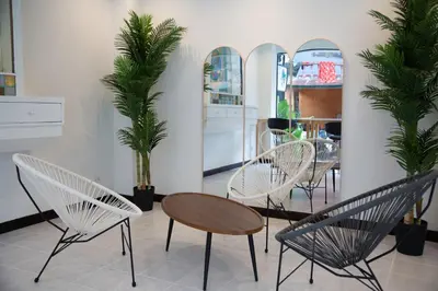 a room with chairs and a table and palm trees at RQ Phuket Kalim Beach Blue Horizon in Patong Beach