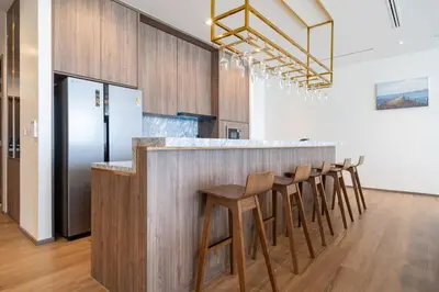 a kitchen with a bar with wooden stools at The Exclusive Sky D1 \u8c6a\u534e4\u5367\u5ba4\u6d77\u666f\u522b\u5885 \u79c1\u4eba12m\u65e0\u8fb9\u6d77\u666f\u6cf3\u6c60 \u6bcf\u65e5\u6e05\u6d01 in Kamala Beach