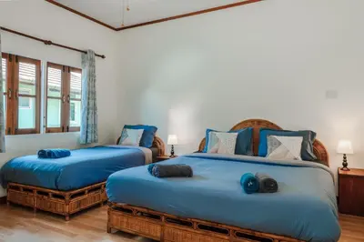 two beds in a room with blue sheets at Tranquility Haven Villa, Kata Beach in Kata Beach