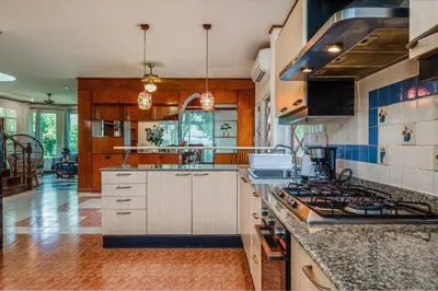 a kitchen with white cabinets and a stove top oven at Tranquility Haven Villa, Kata Beach in Kata Beach