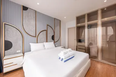 a bedroom with a white bed with towels on it at Bellevue Lagoon Premium Apart Hotel by TropicLook in Bang Tao Beach