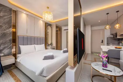 a bedroom with a large bed and a kitchen at Bellevue Lagoon Premium Apart Hotel by TropicLook in Bang Tao Beach