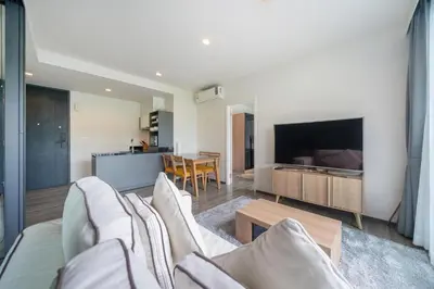 a living room with a couch and a television at Holiday apartment at The Deck by Lofty in Patong Beach