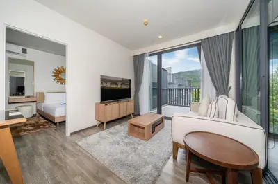 a bedroom with a bed and a living room with a tv at Holiday apartment at The Deck by Lofty in Patong Beach