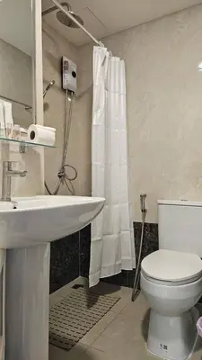a bathroom with a white toilet and a sink at Квартира in Ban Mai Salae
